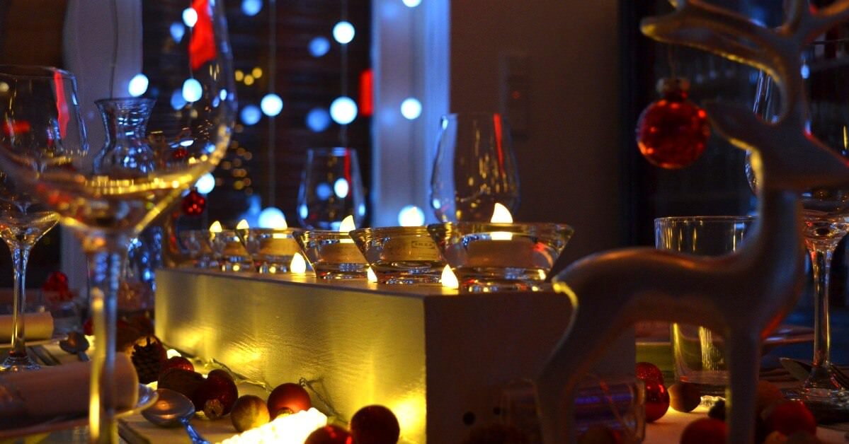 Festlich geschmückter Tisch mit Weihnachtsdeko und Weingläsern mit Wein