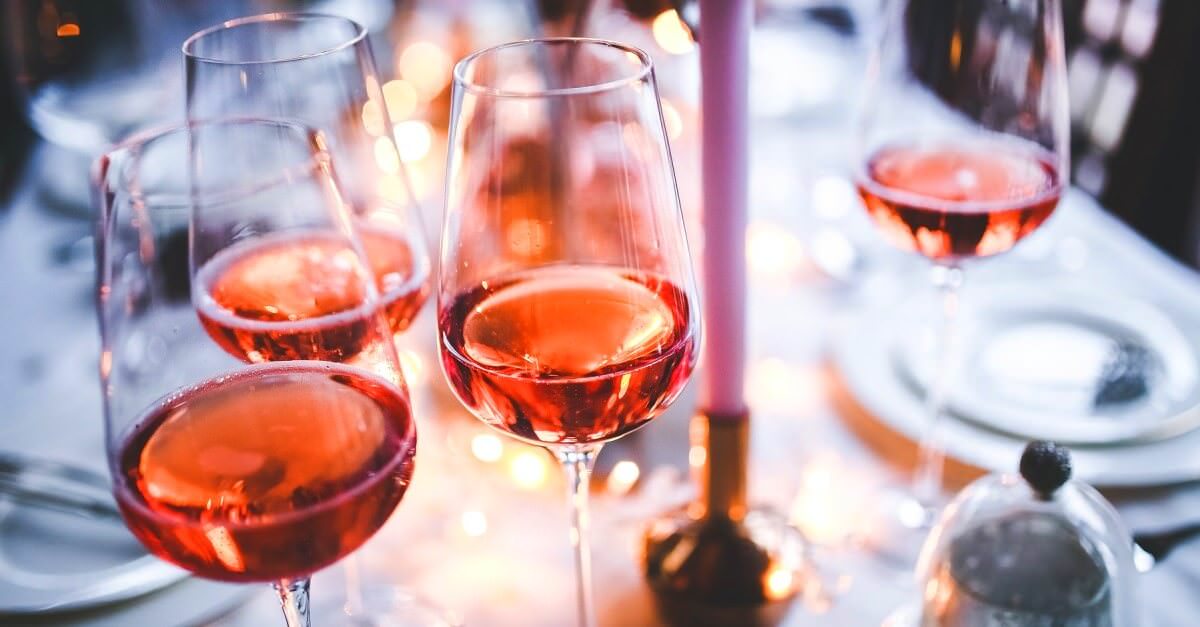 Gläser mit Roséwein auf einer festlichen Tafel