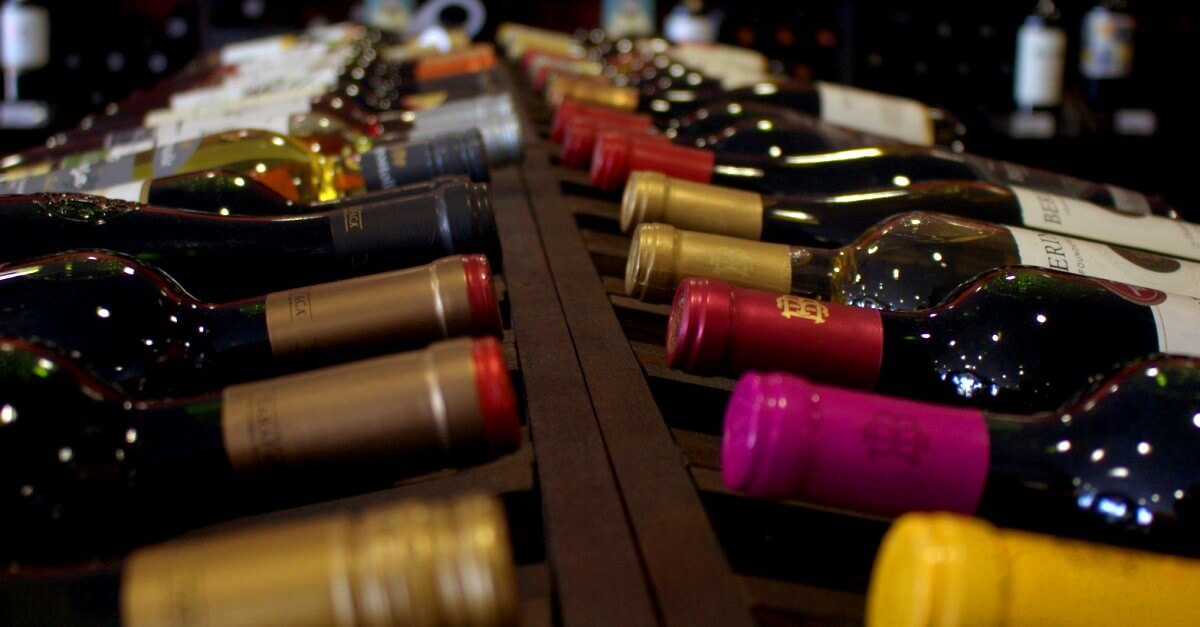 Weinflaschen lagern im Regal und symbolisieren unsere Wein Ratgeber