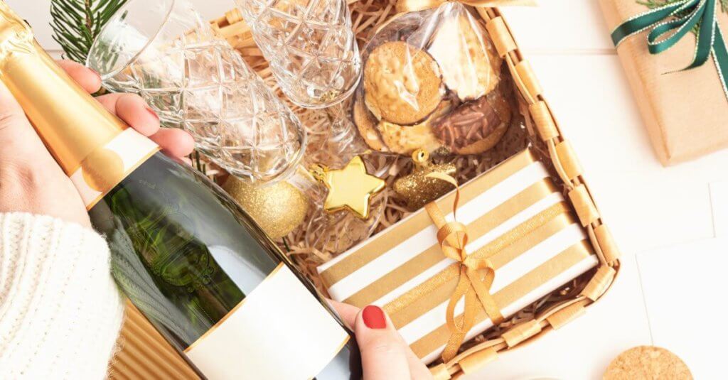 Eine Flasche Schaumwein mit einem weihnachtlichen Geschenkkorb