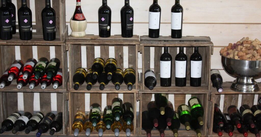Weinflaschen stehen und liegen in einem Holzregal